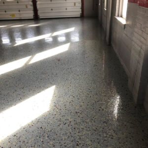 Large garage with gray, white, black and red speckled floor.